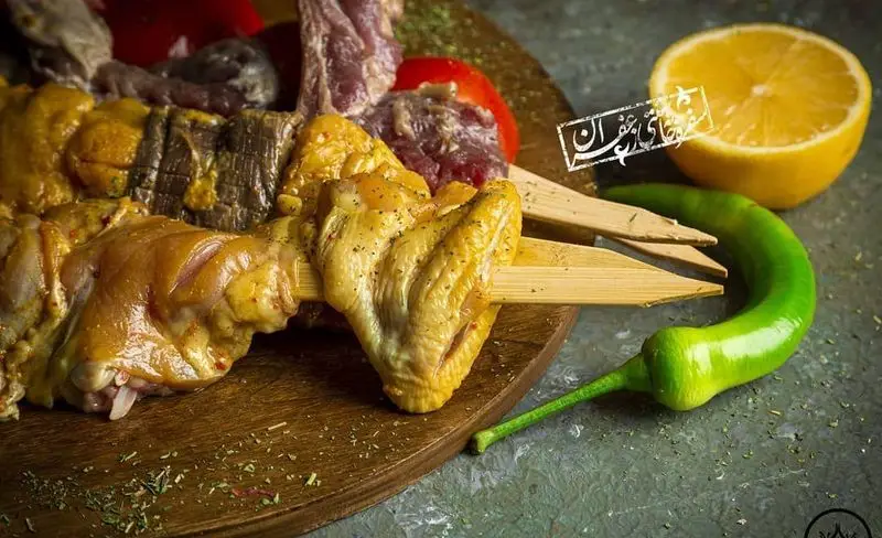 سینی آماده‌سازی کباب‌های لذیذ گل زعفرون شامل جوجه کباب، گوشت گوسفندی و جگر با چاشنی زعفرانی، لیمو و فلفل.