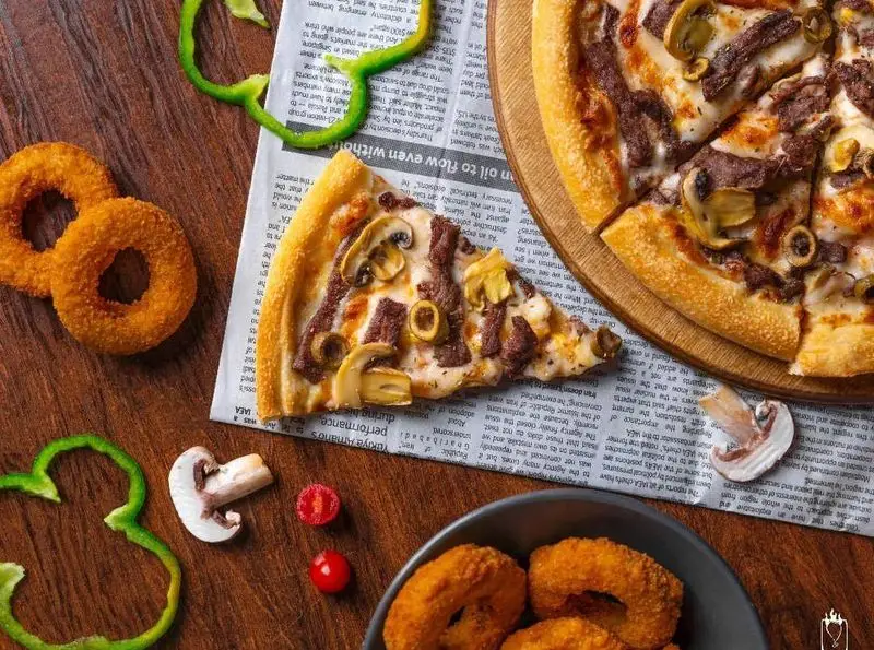 پیتزا گوشت، قارچ و زیتون فست فود جیلیزویلیز پیروزی در تهران، همراه با حلقه‌های پیاز ترد و سبزیجات تازه. طعمی بی‌نظیر.