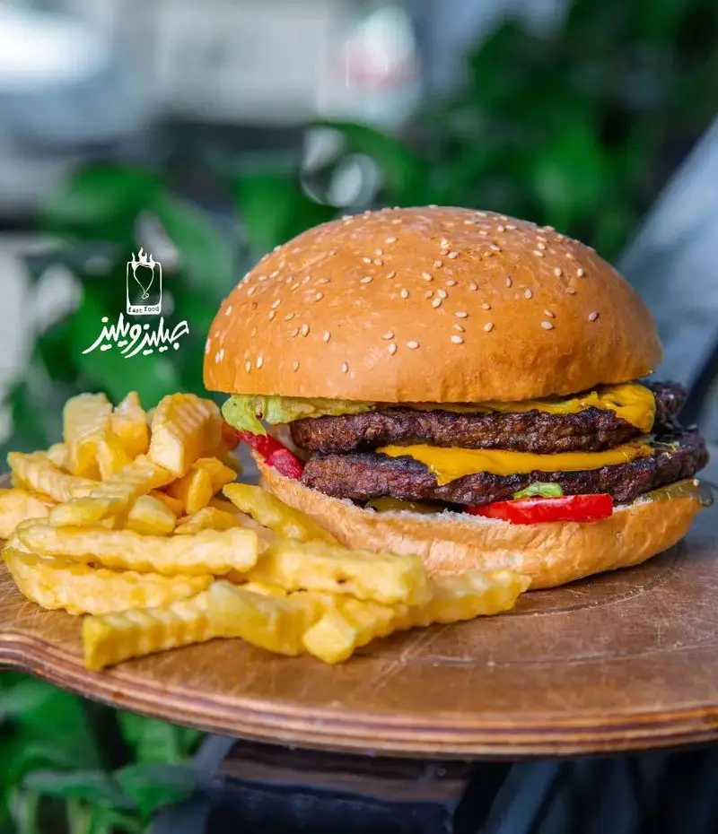 همبرگر دوبل پنیر جیلیزویلیز با سیب زمینی سرخ کرده و نان کنجدی، تصویری خوشمزه از فست فود جیلیزویلیز پیروزی.