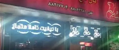 تابلوی روشن کبابی عشایر کباب در شب، با شعار کیفیت کاملا ممتاز و لوگوی آشپز. تلفن تماس: ۸۸۰۹۳۴۸۱ و ۸۸۲۱۷۷۰۴