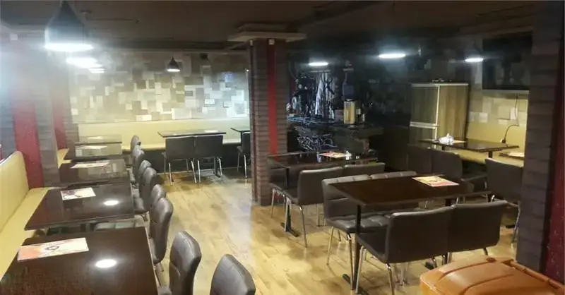 فضای داخلی فست فود گاف، با چیدمان منظم میز و صندلی‌های مدرن و نیمکت‌های راحت. دکوراسیون دلنشین و نورپردازی مناسب، آماده پذیرایی از مشتریان است.