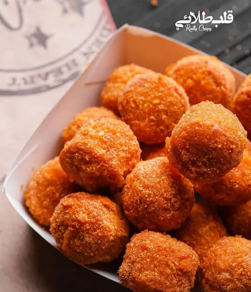 تصویری از سطل پر از توپک‌های مرغ یا پنیر طلایی و کریسپی از فست فود قلب طلایی نیاوران، ایده‌آل برای یک میان‌وعده خوشمزه.