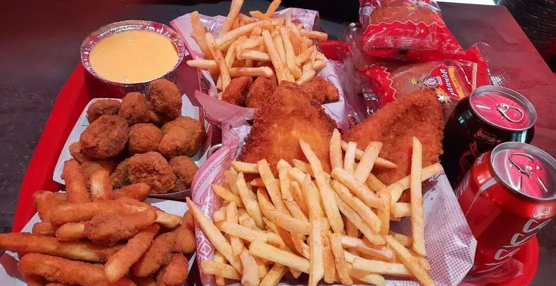 تصویری جذاب از منوی پرطرفدار فست فود قلب طلایی نیاوران: سیب زمینی ترد، مرغ و ماهی سوخاری، سس پنیر و نوشابه خنک.