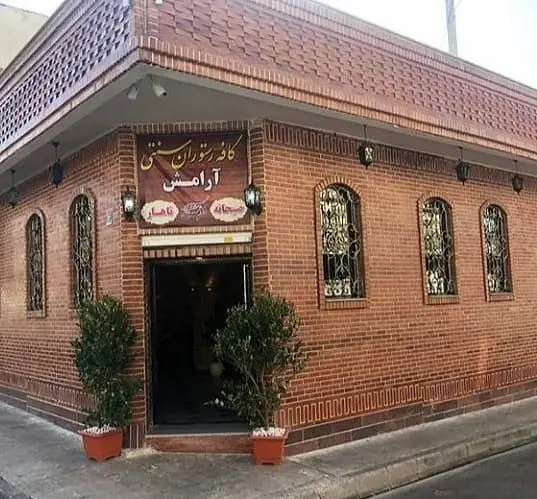 کافه رستوران سنتی آرامش، ساختمانی با نمای آجری، پنجره‌های مشبک و ورودی اصلی. بهترین مکان برای صبحانه و ناهار ایرانی.