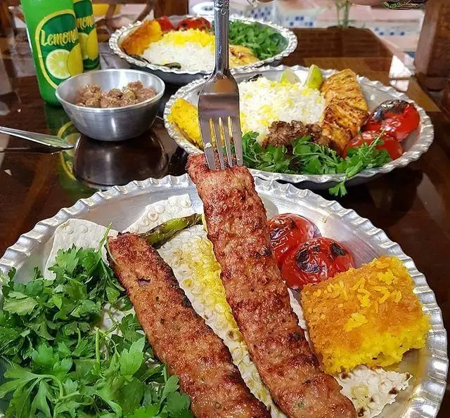 چلو کباب کوبیده و کباب جوجه لذیذ، همراه با ته دیگ زعفرانی و سبزیجات تازه در رستوران سنتي آرامش، بهترین غذای ایرانی.
