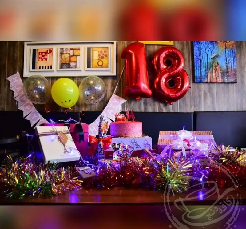 جشن تولد ۱۸ سالگی شاد و دنج در کافه رستوران دنج، با کیک، بادکنک، کادو و دکوراسیون زیبا برای ساخت خاطرات فراموش‌نشدنی.
