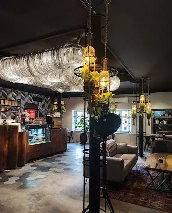 فضای داخلی خاص و هنری سفره خانه هنرمندان؛ نورپردازی چشم‌نواز با بطری‌های وارونه، سقف مدرن و پیشخوان چوبی.