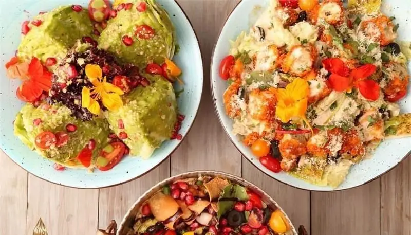 غذاهای رنگارنگ و سالم کافی شاپ سریاس: دو سالاد زیبا با آووکادو، انار، میگو سوخاری و گل‌های خوراکی، به همراه یک فتوچ خوشمزه.