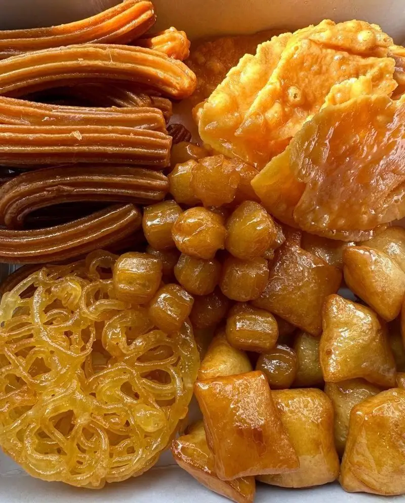 قنادی زولبیار: مجموعه‌ای بی‌نظیر از شیرینی‌های سنتی ایرانی؛ زولبیا، بامیه، گوش‌فیل و لقمه‌قاضی غرق در شهد، خوشمزه و تازه.