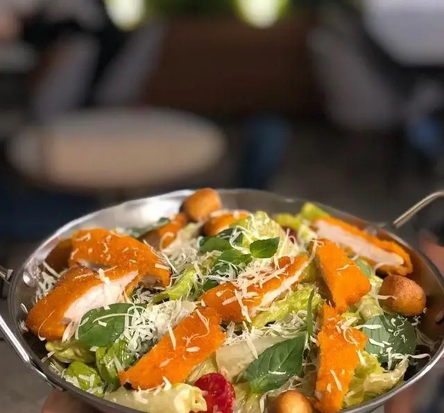 سالاد سزار مرغ سوخاری مجلسی، شامل فیله مرغ ترد، کاهو تازه، پنیر پارمزان، کروتون و ریحان در کافه رستوران مستان.