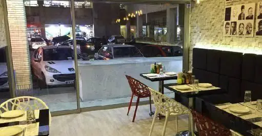 رستوران ایتالیایی مانلی، فضایی شیک و مدرن با چیدمان میز و صندلی‌های جذاب، آماده پذیرایی از میهمانان در محیطی دلنشین و دکوراسیون خاص.