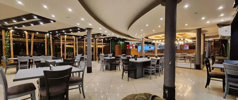 فضای داخلی شیک و مدرن رستوران پیتزا سه فر، با چیدمان تمیز میز و صندلی‌ها و نورپردازی دلنشین، ایده‌آل برای یک وعده غذایی عالی.