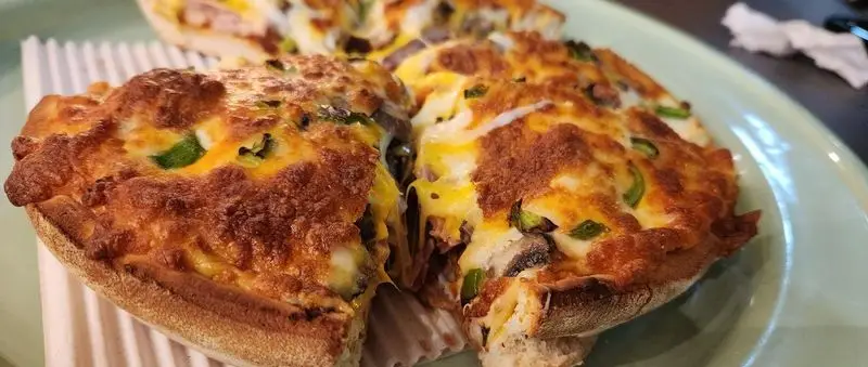 پیتزا سه فر: برش های پیتزا با پنیر آب شده، فلفل دلمه ای تازه و قارچ، تصویری دلنشین و خوشمزه از منوی رستوران.