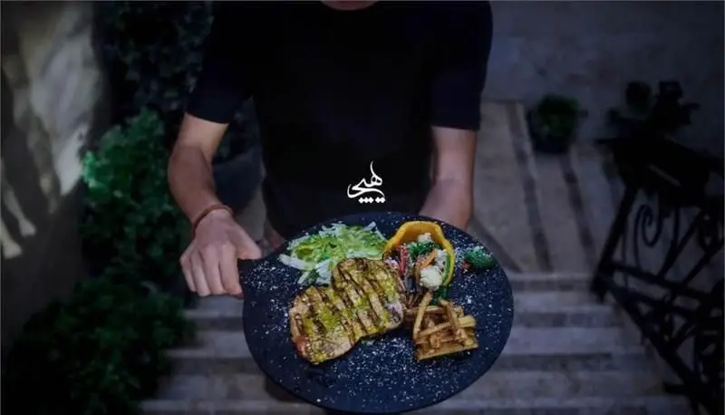 سرو استیک گریل با سالاد، تاکو و سیب‌زمینی سرخ‌کرده روی بشقابی زیبا توسط پرسنل در کافی شاپ هیچ. منوی غذایی لذیذ.