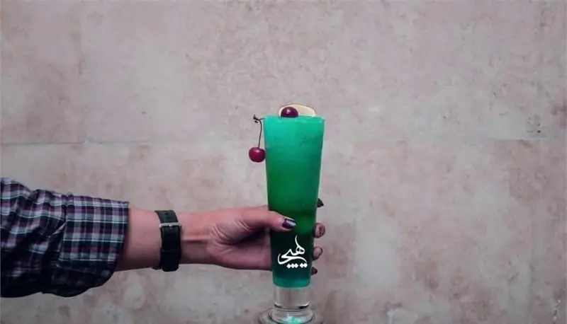 نوشیدنی سبز و خنک، تزئین شده با گیلاس، در لیوان بلند کافی شاپ هیچ. طعمی خاص و تجربه‌ای بی‌نظیر برای مشتریان.