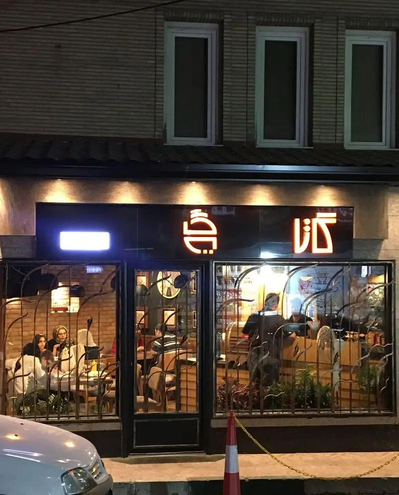 تصویری از نمای شب فست فود گاتا، با نورپردازی گرم و مشتریانی که در حال صرف غذا در فضای دلنشین و دنج رستوران هستند.