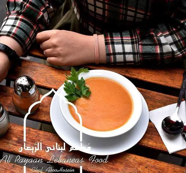 تصویری از سوپ عدس لبنانی خوشمزه و تازه در رستوران الریان، بهترین تجربه غذای لبنانی با کیفیت عالی روی میز چوبی.