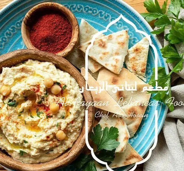 غذاهای خوشمزه رستوران لبنانی الریان: حمص تازه با نان پیتا، روغن زیتون، نخود و پاپریکا. تجربه طعم اصیل.