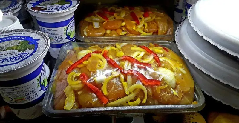 انواع خوراک مرغ فست فود سه ستاره با پیاز و فلفل دلمه در بسته‌بندی شفاف آماده عرضه، کنار ماست‌های خوشگوار.