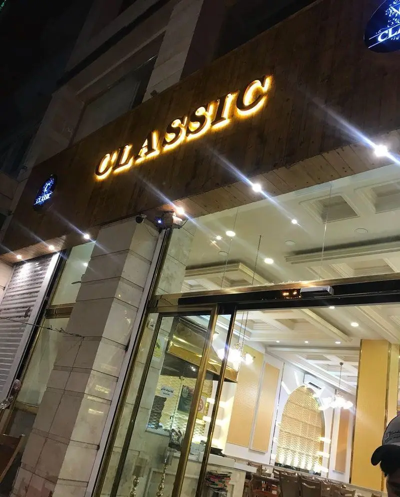 نمای بیرونی جگرسرای کلاسیک در شب با تابلوی درخشان "CLASSIC" روی چوب و ورودی شیک. مقصدی ایده‌آل برای لذت بردن از بهترین جگر و کباب تازه.