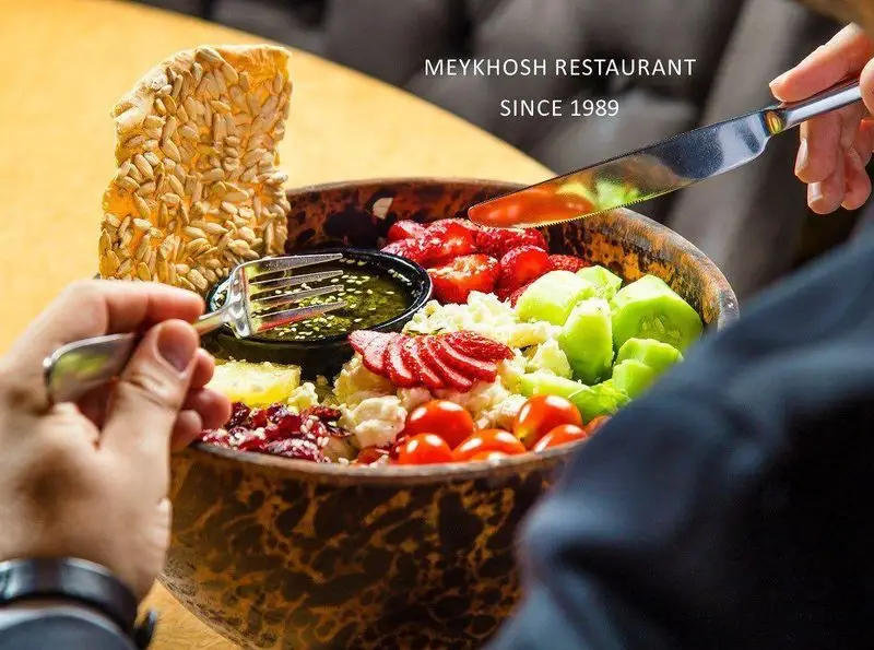 سالاد تازه و خوش‌رنگ رستوران میخوش: تجربه‌ای لذیذ از غذای سالم، شامل توت‌فرنگی، خیار، گوجه و مغز آفتابگردان، برای طعمی به یادماندنی.