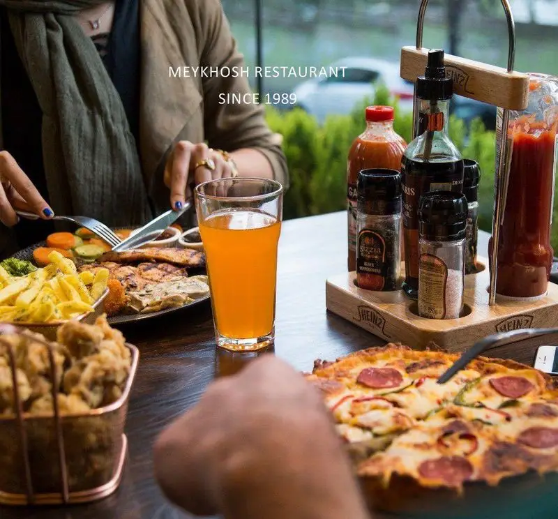 نمایی از مشتریان در رستوران و پیتزا میخوش، لذت بردن از پیتزا تازه و غذاهای اصلی در محیطی دلنشین. بهترین غذاهای ایرانی و فست فود.