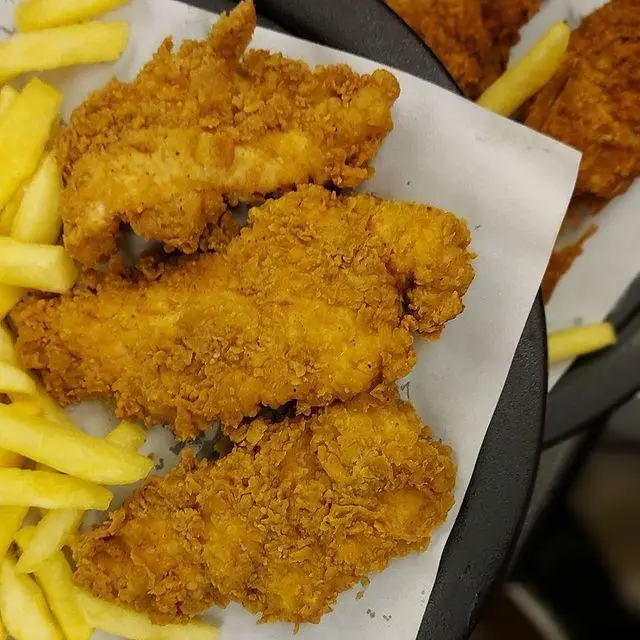 چیکن استریپس ترد و طلایی کافه رستوران توژی همراه با سیب‌زمینی سرخ‌کرده. یک وعده خوشمزه و کامل برای دوستداران مرغ سوخاری.