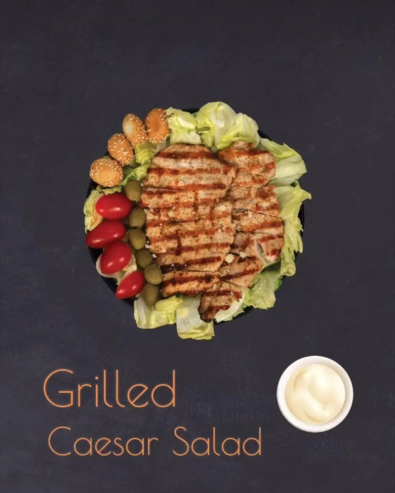 سالاد سزار گریل شده کافه رستوران توژی با مرغ گریل، کاهو، گوجه گیلاسی، زیتون، نان و سس، غذایی سالم و خوشمزه.