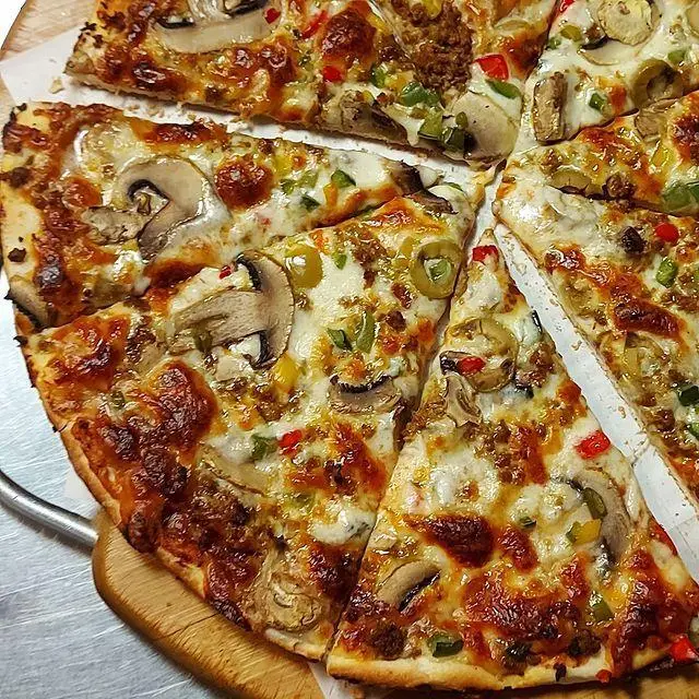 پیتزای تازه و داغ کافه رستوران توژی با قارچ، فلفل دلمه سبز و قرمز، زیتون و گوشت چرخکرده. پنیر طلایی و نان برشته.