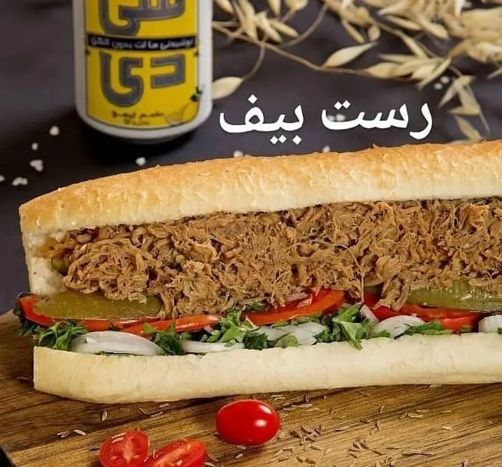 ساندویچ رست بیف خانواده، غذای خوشمزه و کامل با گوشت ریش ریش، سبزیجات تازه، پیاز، گوجه و خیارشور در نان باگت.