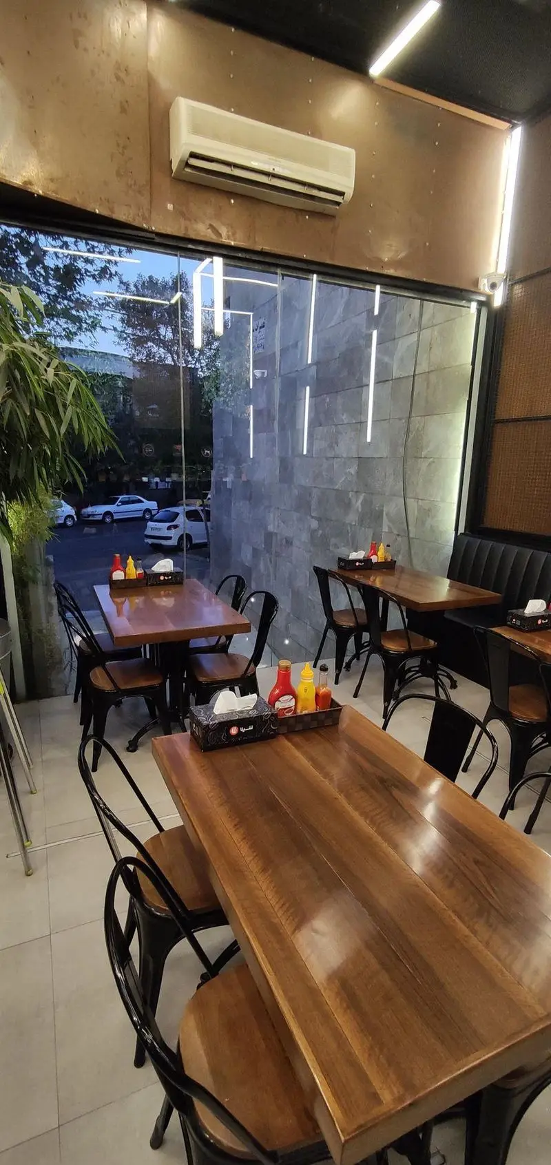 فضای داخلی دنج و مدرن فست فود شیلا شعبه دولت با میز و صندلی‌های چوبی، آماده پذیرایی از مشتریان در محیطی دلنشین و آرام.