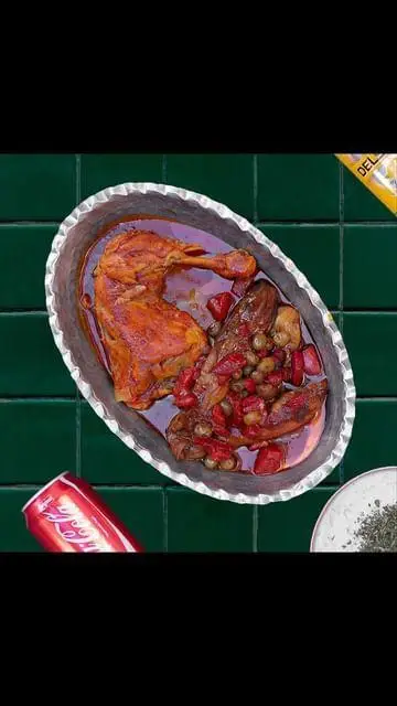 تصویر خورش مرغ و بادمجان لذیذ تهیه غذا و کترینگ سدره تجریش در ظرف سنتی مسی، آماده سرو، با نوشابه و سبزی معطر.