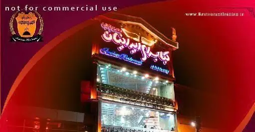 نمای خارجی رستوران ایرانیان در شب با تابلوی نئونی درخشان "کبابسرای ایرانیان"، مکانی ایده‌آل برای غذای اصیل ایرانی.