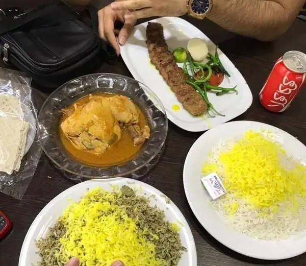 میز غذای رستوران ایرانیان شامل کباب کوبیده، خورشت مرغ زعفرانی، سبزی پلو و برنج زعفرانی؛ طعم اصیل غذای ایرانی را تجربه کنید.