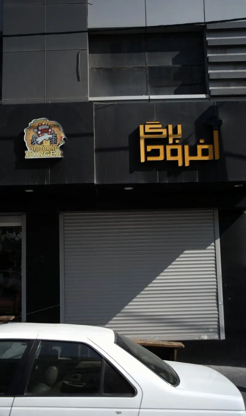 تصویر نمای بیرونی مغازه فست فود Offroad Burger با تابلوی آفرود برگر و لوگوی ماشین آفرود، در یک روز آفتابی.