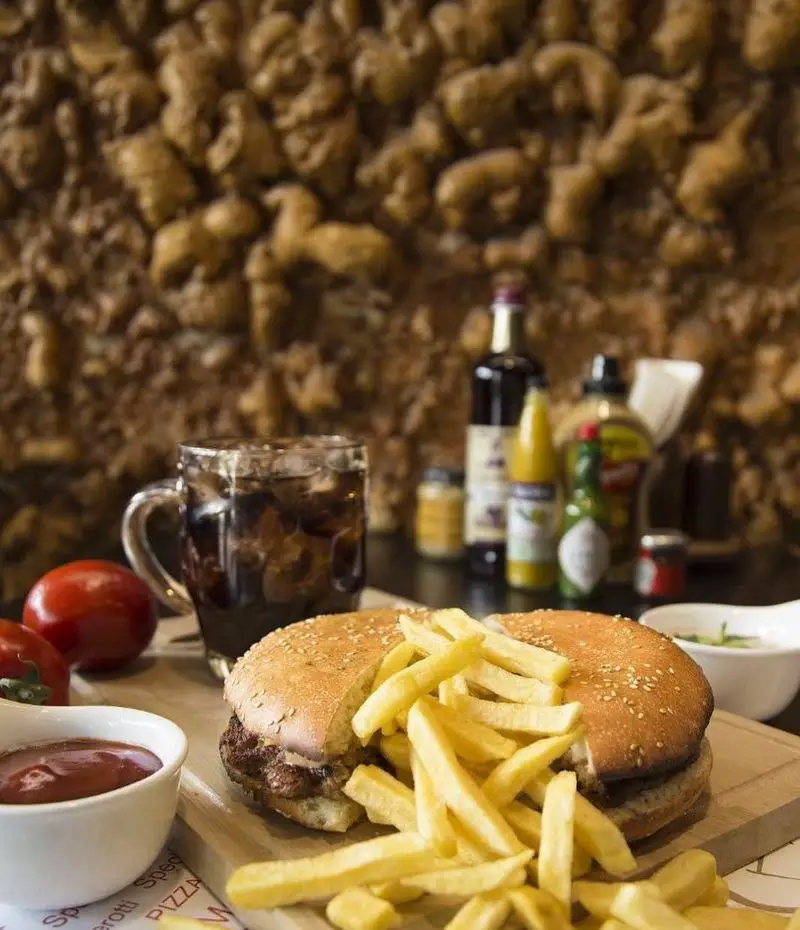 همبرگر ژولی با نان کنجدی، سیب زمینی سرخ کرده طلایی، نوشابه خنک و سس کچاپ در محیط دلنشین رستوران ایتالیایی ژولی.