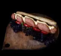 ساندویچ هات داگ ویژه و خوشمزه فست فود هات باکس با سس خردل و مخلفات تازه روی تخته چوبی، طعمی به یاد ماندنی.