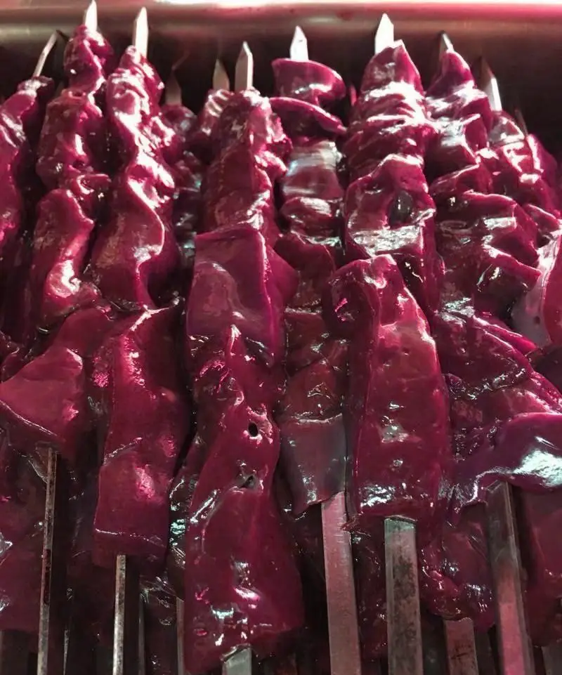 سیخ‌های جگر خام و تازه گوسفندی با رنگی درخشان، آماده طبخ در جگر سرای ۱۱۰. تجربه بهترین کباب جگر در تهران با ما.