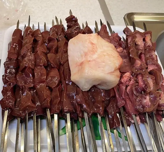 تعداد زیادی سیخ جگر، دل، قلوه و چربی خام آماده کباب در جگر سرای ۱۱۰. بهترین و تازه‌ترین مواد برای کبابی خوشمزه و اصیل ایرانی.