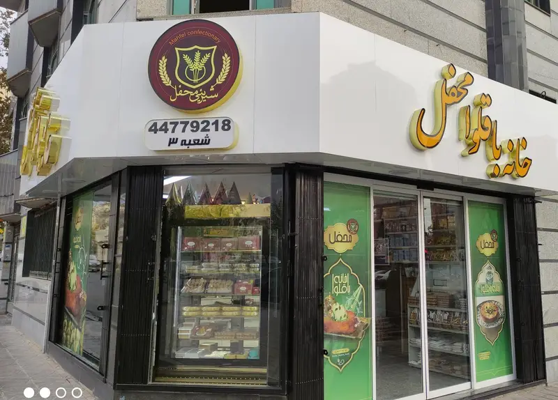 ورودی جذاب خانه باقلوا محفل، شعبه ۳، با تابلو و ویترین انواع شیرینی، باقلوا و دسرهای خوش طعم. شماره تماس: 44779218.