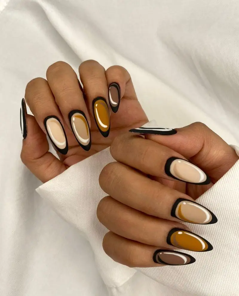 طراحی ناخن پاییزی شیک با ترکیب رنگ‌های قهوه‌ای، خردلی و کرم با خطوط مشکی و سفید روی ناخن‌های بادامی بلند دخترانه