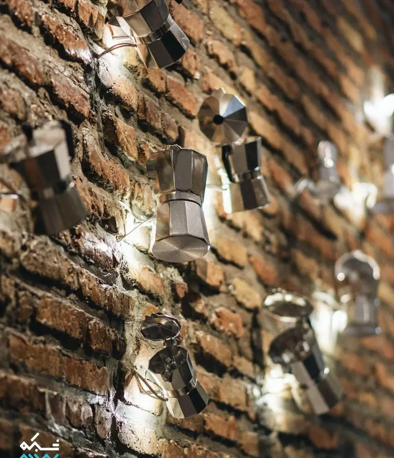 دکوراسیون خاص کافه لایت با موکاپات‌های درخشان روی دیوار آجری، فضایی گرم و دلنشین برای علاقه‌مندان به قهوه ایجاد کرده است.