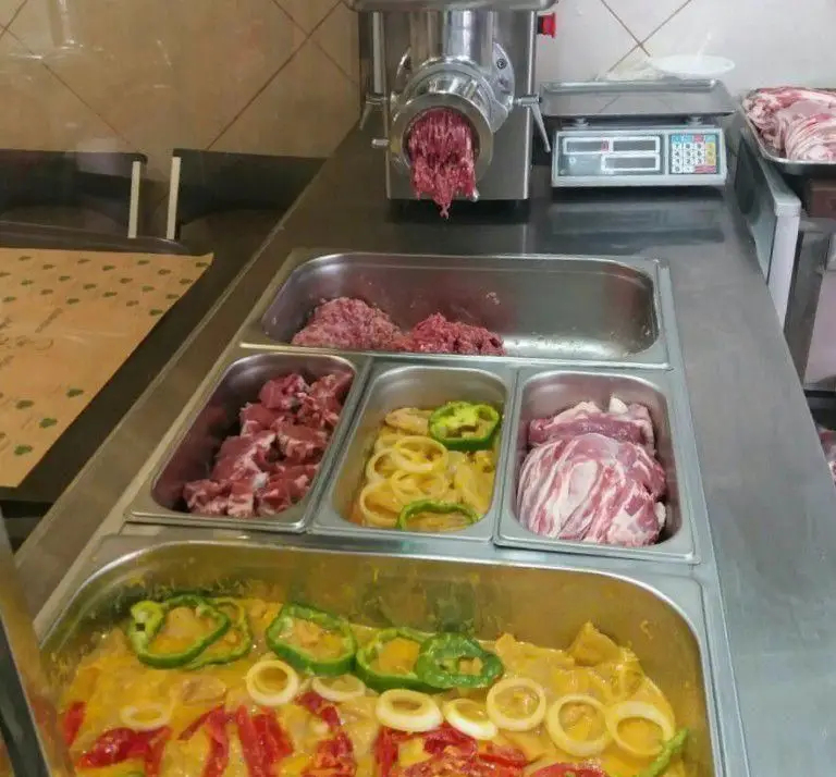 گوشت تازه و مرغوب در حال آماده‌سازی برای کباب‌های لذیذ در کبابخانه اصیل گلپایگانی؛ شامل چرخ‌کرده، تکه‌ای، سبزیجات و مرینیت خاص.