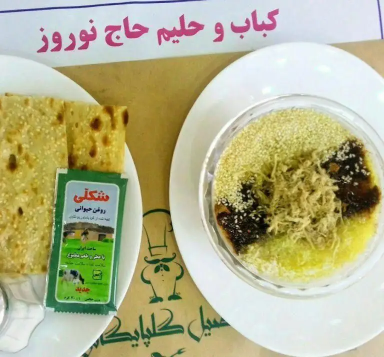 صبحانه ایرانی کامل کبابخانه اصیل گلپایگانی: حلیم با روغن حیوانی، کنجد و نان تازه. غذایی سنتی و مقوی برای آغاز روزی پرانرژی.