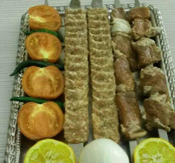 سینی متنوع کباب اصیل ایرانی شامل کوبیده و کباب گوشت، با گوجه، فلفل، لیمو و پیاز از کبابخانه اصیل گلپایگانی.