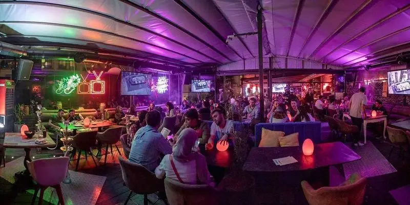 فضای پر جنب و جوش لایف کافه، یک کافه رستوران مدرن با دکوراسیون جذاب و نورپردازی نئونی، مناسب دورهمی و سرو قلیان.