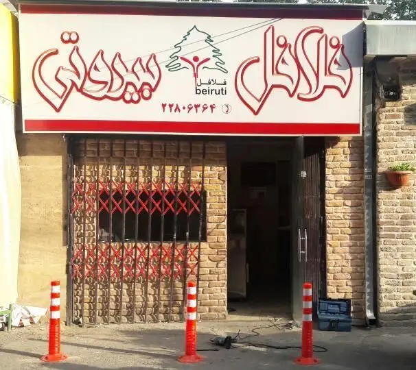 نمای خارجی رستوران فلافل بیروتی نیاوران با تابلوی قرمز و سفید، شماره تلفن و در ورودی، آماده پذیرایی از مشتریان.