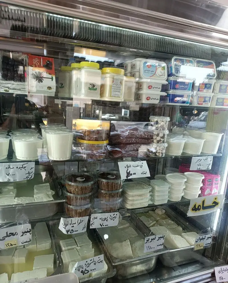 ویترین شلوغ و جذاب فروشگاه لبنیات سنتی هفت چنار، نمایشگر انواع پنیر، ماست، خامه، حلوا و محصولات سنتی تازه و باکیفیت.