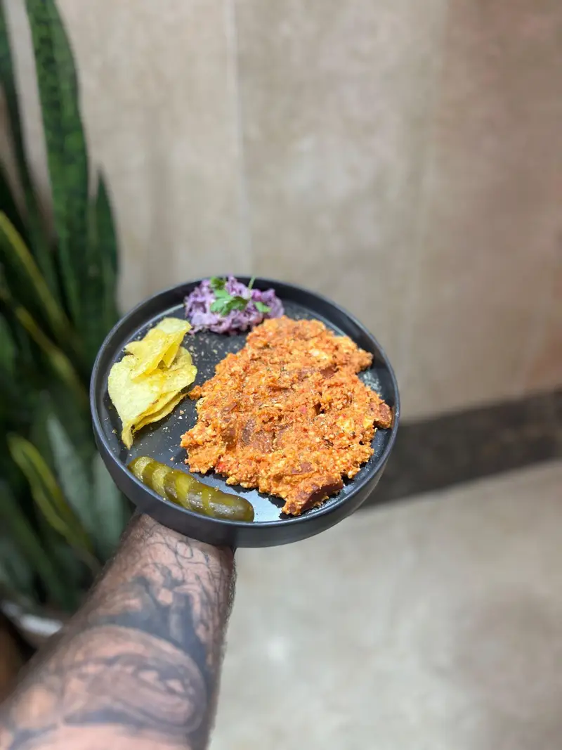 خوراک لذیذ و رنگارنگ کافه پارس همراه چیپس، کلم بنفش و خیارشور؛ انتخابی عالی برای وعده‌های شما.