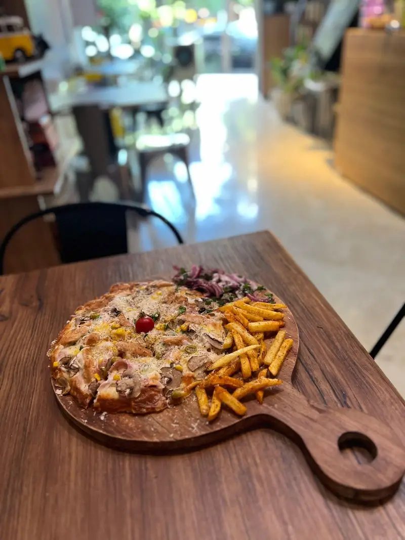 سفارش پیتزا مخصوص کافه پارس با قارچ، زیتون، گوشت، ذرت و پنیر، همراه سیب زمینی سرخ کرده و سالاد پیاز قرمز.